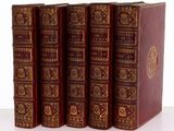 quatre livres sont alignés sur une surface blanche