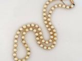 gros plan d'un collier de perles sur une surface blanche