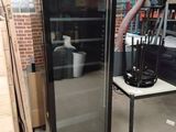 un réfrigérateur à porte vitrée placé au milieu d'une pièce