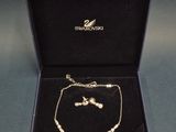 a gold necklace and bracelet set in a black box