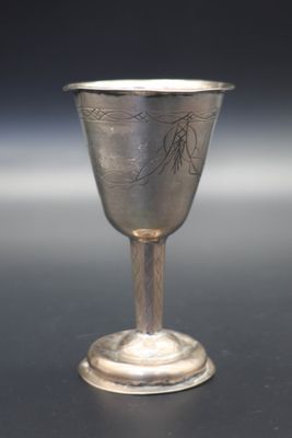 un gobelet en argent posé sur une surface noire