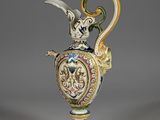 a vase with a bird on top of it on a table