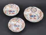 three chinese porcelain bowls with floral designs on them on a black surface