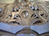 carvings on the ceiling of a building with a clock in the background