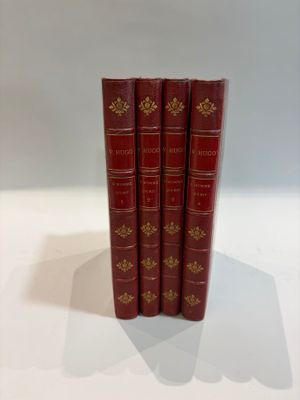 three red books sitting on top of each other on a white surface
