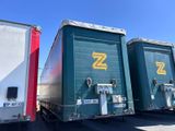 trois semi-remorques garées les unes à côté des autres sur un parking