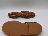 a pair of brown sandals on a white surface