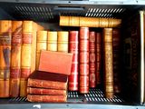 many old books in a metal box on the shelf