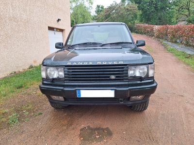 une Land Rover noire garée sur le bord d'un chemin de terre