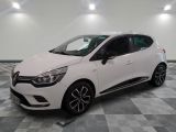 une voiture blanche est garée dans une pièce au sol à carreaux