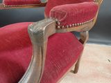 a red chair with a wooden frame and red upholstered seat