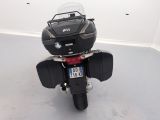 a black motorcycle parked in a room with a white wall