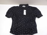 the shirt is black and white with white dots on it