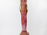 a glass sculpture of a woman holding a bird on a pedestal