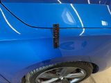 a close up of a blue car with a sticker on it