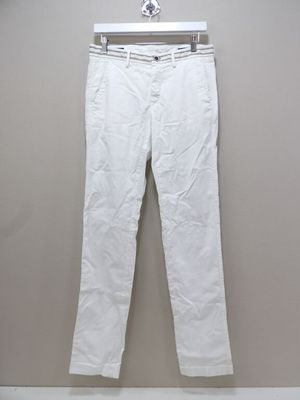un pantalon blanc suspendu à un cintre contre un mur
