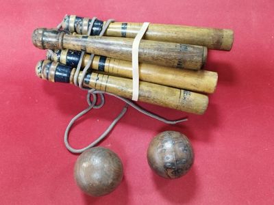 un tas de bâtonnets en bois et une balle posés sur une surface rouge