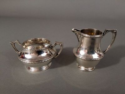 paire de sucrier et de pot à crème en métal argenté sur fond gris