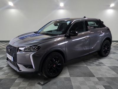 un 4x4 gris garé dans une pièce au sol en damier