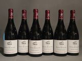 six bottles of wine are lined up in a row on a table