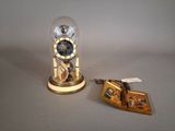 a clock inside of a glass dome next to a keychain