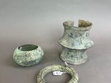 trois pièces de poterie posées sur une table