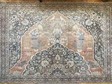tapis posé sur le sol d'une pièce dotée d'un parquet et d'une chaise