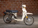 a small motor bike parked in front of a brick wall