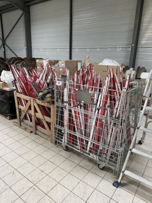 a lot of red and white baseball bats in a cage