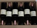 six bottles of wine in a box on a table