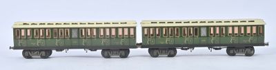 deux petits trains miniatures posés côte à côte sur une surface blanche