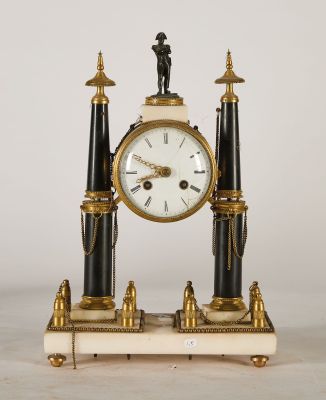 a black and gold clock with a man standing on top of it