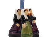 une petite figurine représentant deux personnes tenant une bougie