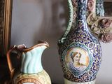 two vases sitting on a table next to a mirror