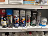 de nombreux pots de peinture sur une étagère dans un magasin