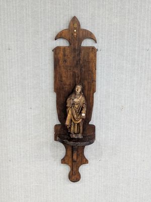 a wooden sculpture of a man on a shelf