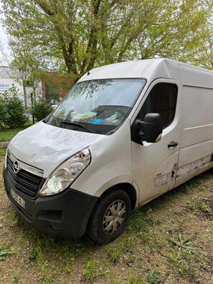 a white van parked in the grass next to a tree
