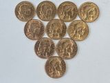 un tas de pièces d'or posé sur une surface blanche