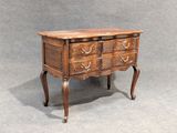 a small wooden chest of drawers with drawers on it