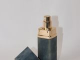 un petit flacon de parfum posé sur une surface blanche