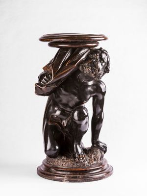 une image représentant la statue d'un homme avec un bol sur la tête