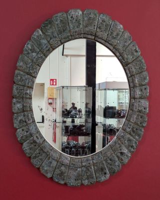 a round mirror hanging on a red wall in a room