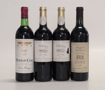 quatre bouteilles de vin sont alignées sur une surface blanche