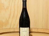 une bouteille de vin posée sur un tonneau