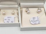 three pairs of pearl earrings in a box with price tags on them