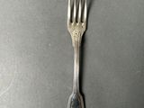 a silver fork on a black surface with a silver handle