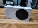 a white box with a black speaker on a wooden table