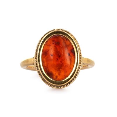 une image représentant une bague en or jaune sertie d'une pierre rouge