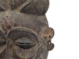 an image of a wooden mask with a flower on it ' s head