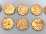 un groupe de six pièces d'or posées sur une surface blanche